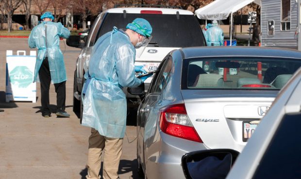 FILE: People line up in their cars as members of the Utah National Guard give COVID-19 swab tests a...