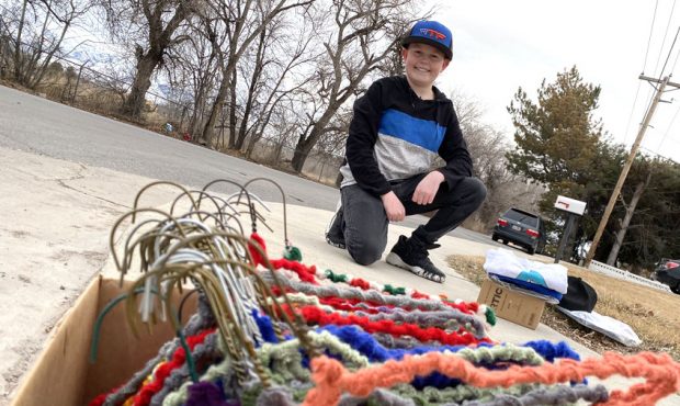 Young entrepreneur Talyn Roberts, age 14, sells crocheted hangers on a street corner in his neighbo...