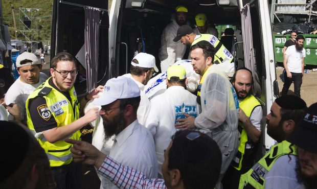 Rescue workers carry a dead body into an ambulance after dozens were killed in crush at a religious...