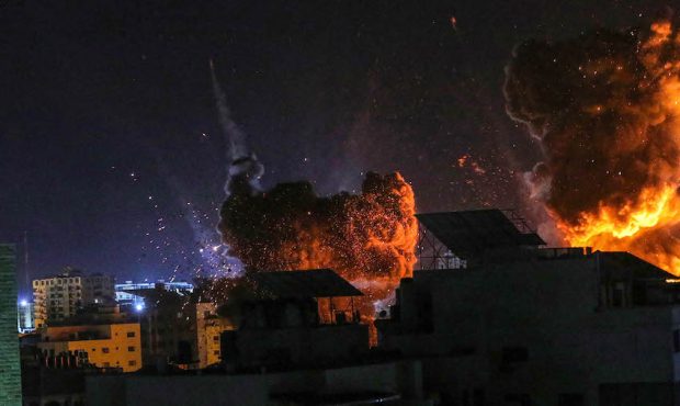 Fire and smoke rise above buildings in Gaza City as Israeli warplanes target a governmental buildin...