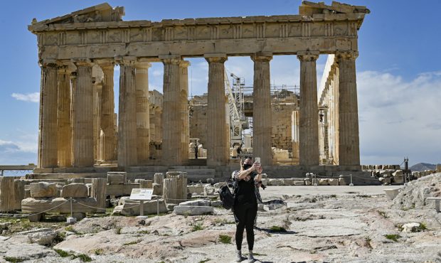 A visitor takes a selfie with the Parthenon temple in the background of the Athenian Acropolis on M...
