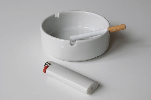 white lighter and ashtray with unlit cigarette