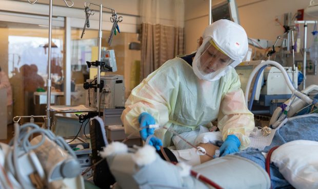 Healthcare workers care for a COVID-19 patient in the ICU at Intermountain Medical Center in Murray...