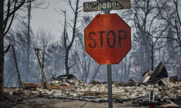 A stop sign and street signage peeled and cracking after intense heat from a wildfire in the afterm...