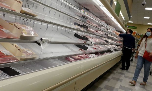 Shelves displaying meat are partially empty as shoppers makes their way through a supermarket on Ja...
