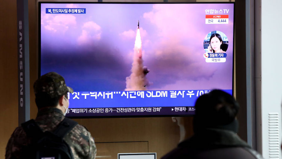 People watch a TV at the Seoul Railway Station showing a file image of a North Korean missile launc...