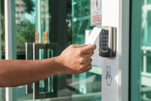 Hand using security key card scanning to open the door