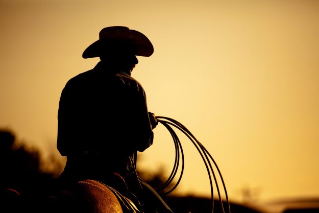 cowboy with lasso silhouette at small-town rodeo. Days of 47 Rodeo