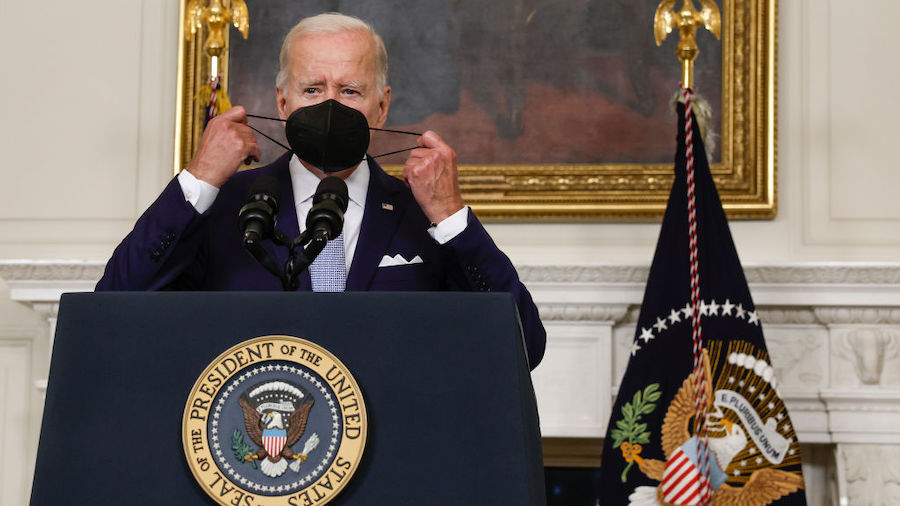 President Joe Biden removes his mask as he delivers remarks on the Inflation Reduction Act of 2022 ...