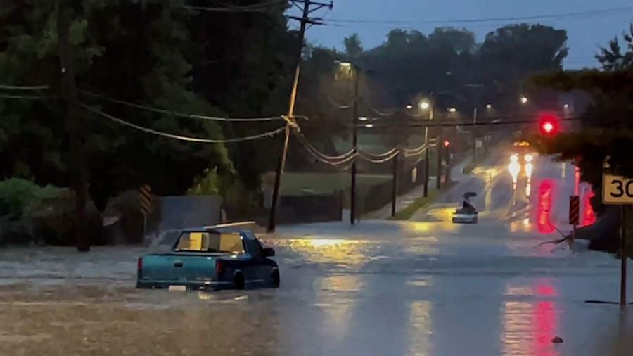 Floodwaters surround a truck on a street in the St. Louis area on Tuesday morning. (KMOV via CNN)...