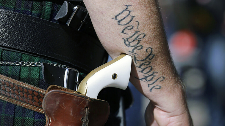 FILE - In this Jan. 26, 2015 file photo, a supporter of open carry gun laws, wears a pistol as he p...
