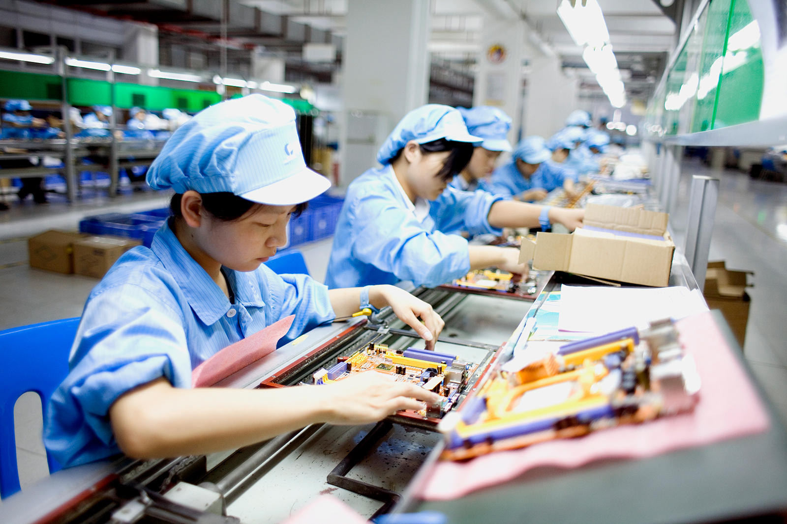 Workers assemble laptop computer on the assembly line at Hasee Computer company's manufacturing cen...