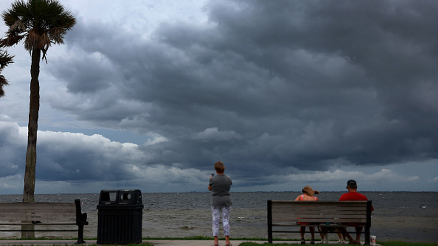 ST. PETERSBURG, FLORIDA - SEPTEMBER 27: People look out as clouds from the approaching Hurricane Ia...