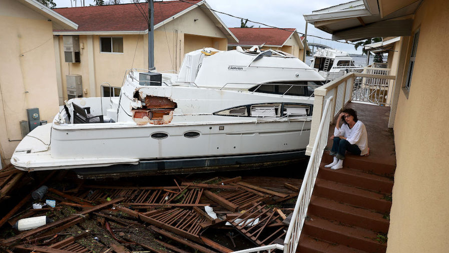 Brenda Brennan sits next to a boat that pushed against her apartment when Hurricane Ian passed thro...