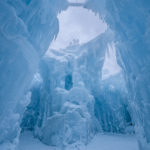 Ice Castles tower tall above view with bridges and archways between them. (AJ Mellor, Ice Castles)
