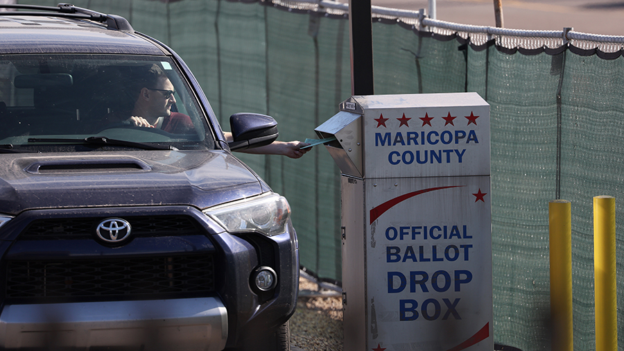 A voter drops his ballot into a drop box at Maricopa County....