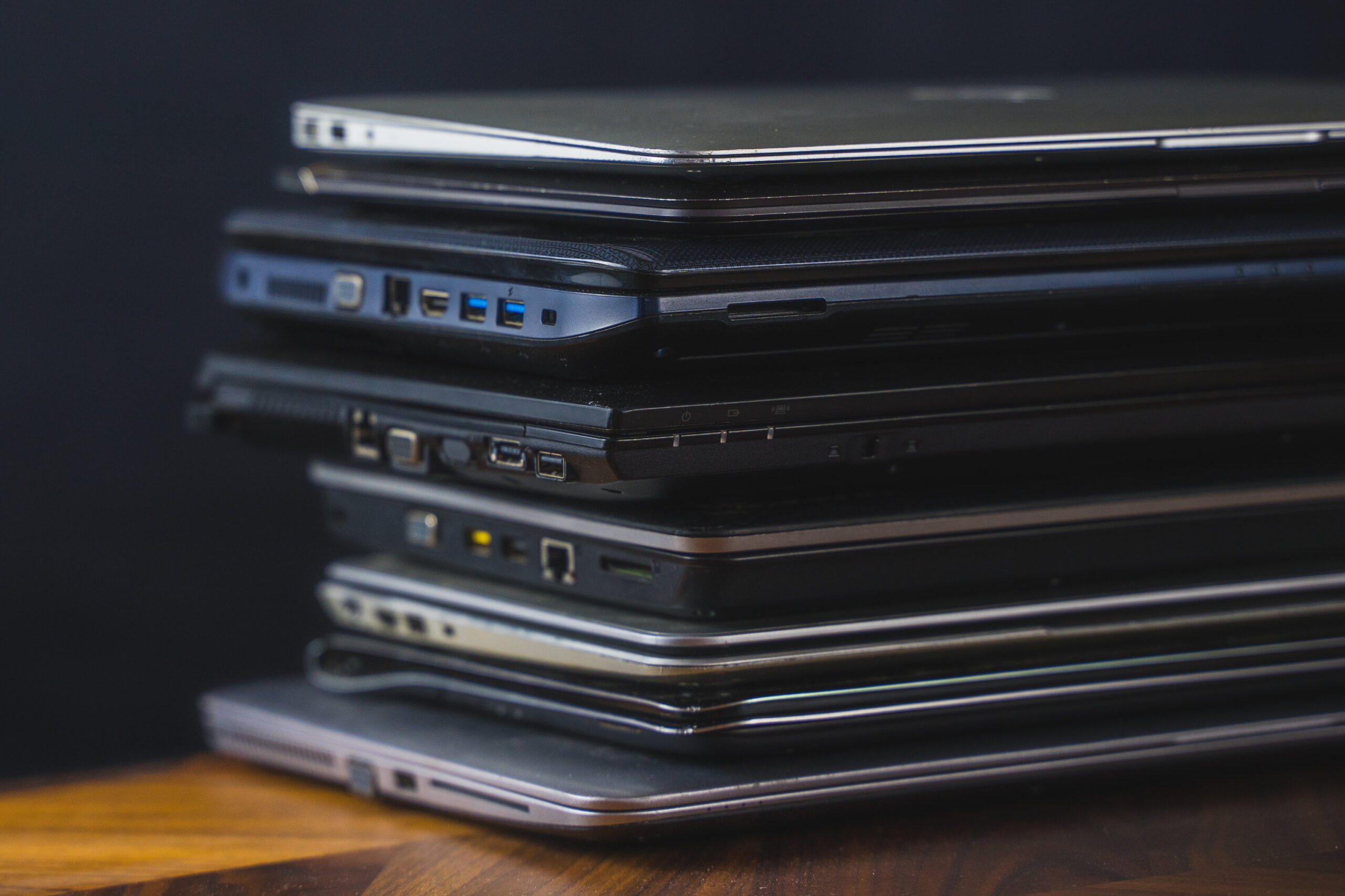 Stack of old laptops with dark background...