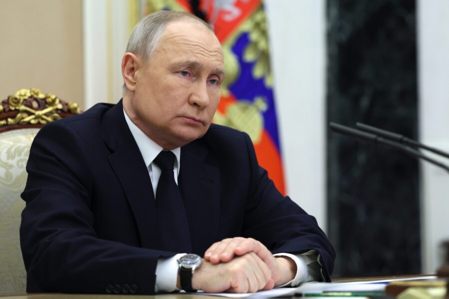 Russian President Vladimir Putin listens to Russian Transport Minister Vitaly Savelyev during their...