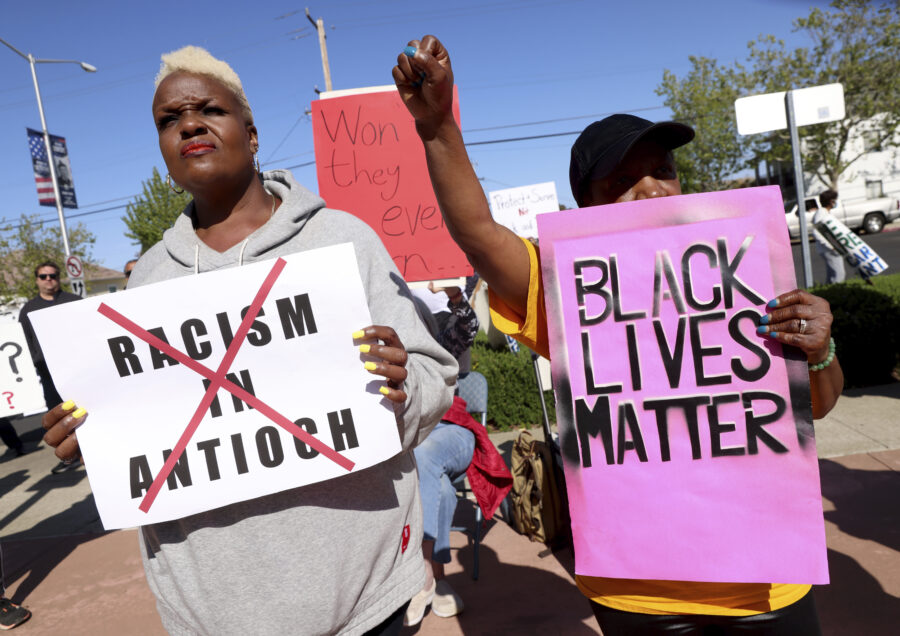 Kiora Hansen and Della Currie, from left, protest during a rally at Antioch police headquarters in ...