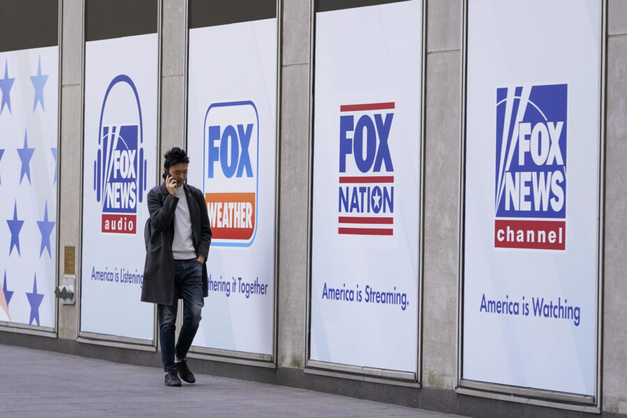 File - A man walks past the News Corp. and Fox News headquarters on Wednesday, April 19, 2023, in N...