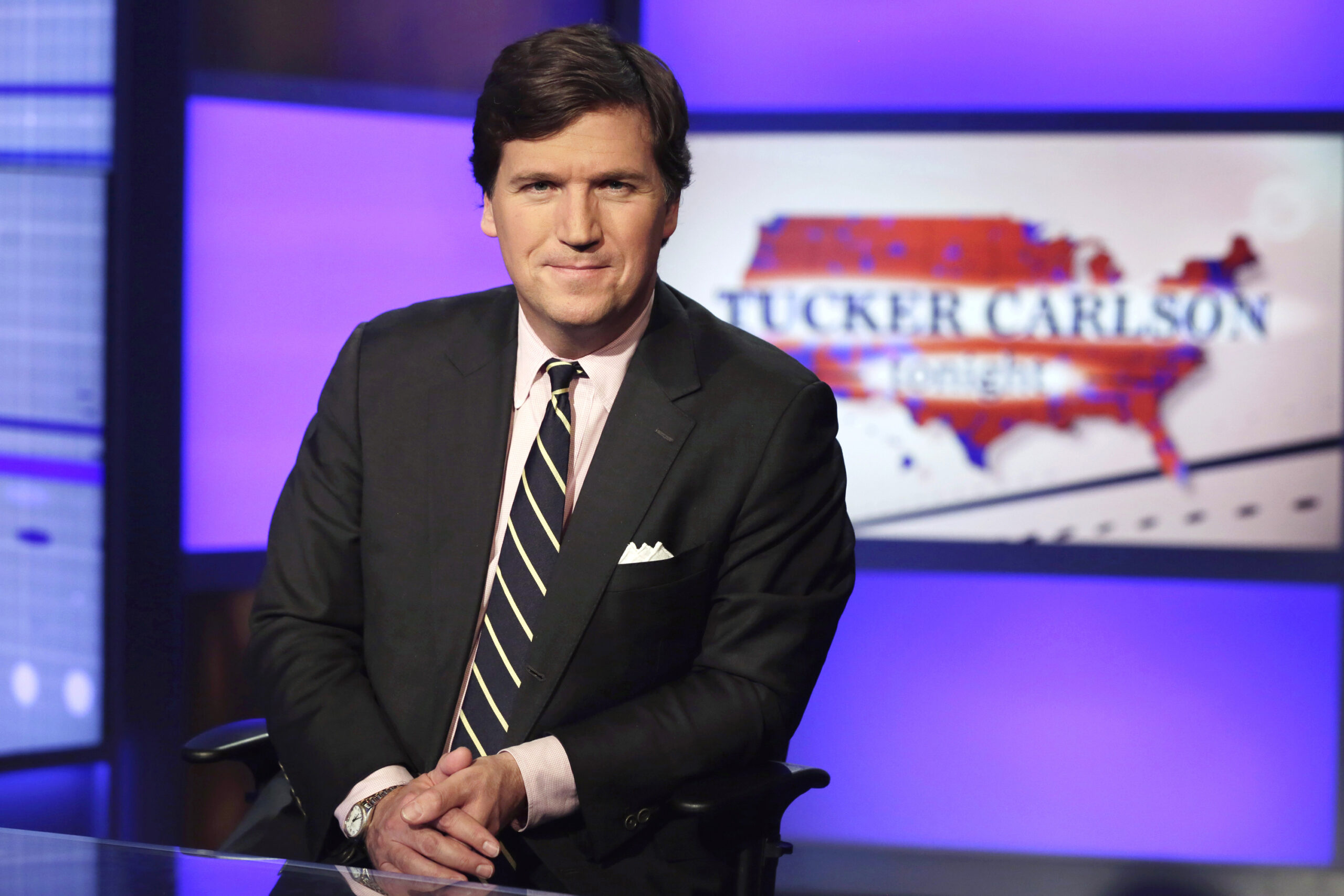 FILE - Tucker Carlson, host of "Tucker Carlson Tonight," poses for photos in a Fox News Channel stu...