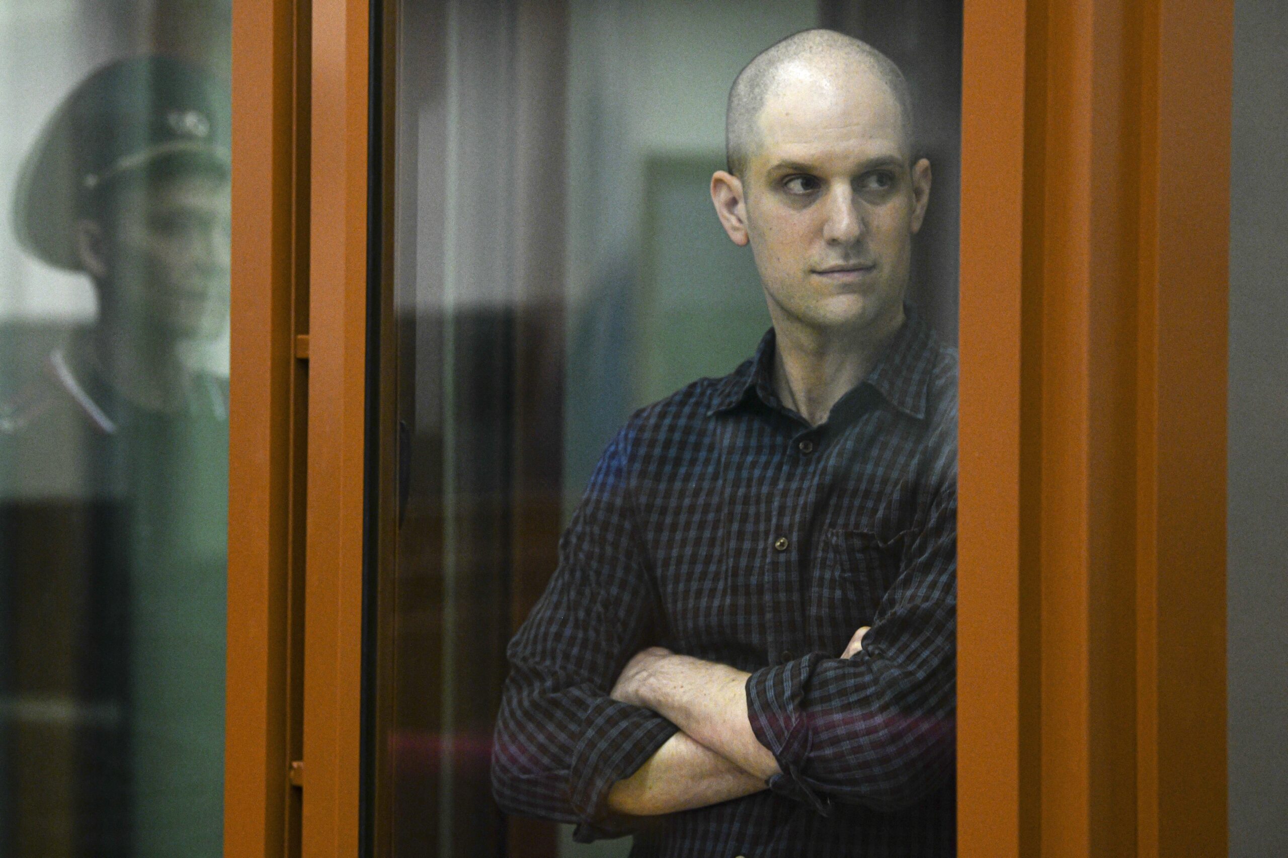 FILE - Wall Street Journal reporter Evan Gershkovich stands in a glass cage in a courtroom in Yekat...